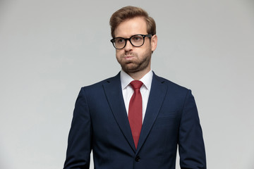 businessman standing and puffing cheeks anxious