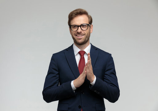 businessman standing and rubbing hands happy