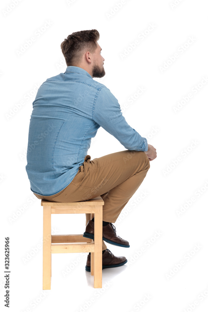 Poster young casual man in denim shirt sitting and thinking