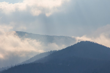 Silhouette of mountains in clouds near Carpathian village Yaremche at sunset. Ukraine