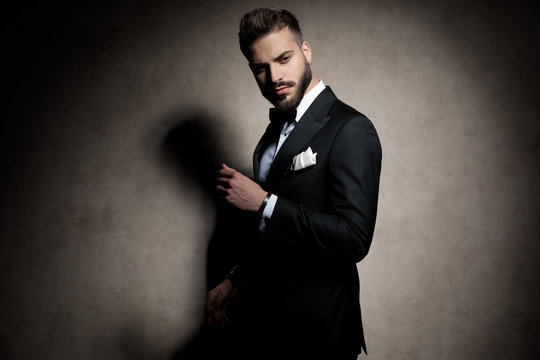 sexy elegant young model in tuxedo holding hand in a fashion pose