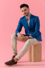 sexy young smart casual model sitting on a wooden box