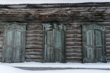 Facade of an old wooden house with closed shutters