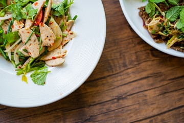 A portion of food on the white dish, wood background.