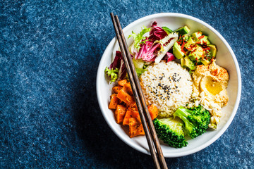 Vegan rice and vegetables salad, top view. Macrobiotic set with rice, hummus, avocado, broccoli and sweet potato. - obrazy, fototapety, plakaty