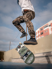 primer plano de las piernas y la tabla de un skater cuando intenta un truco