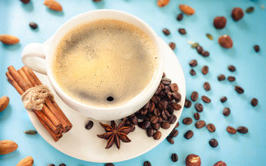 aromatic coffee in a white cup, with cinnamon and anise on a blue background
