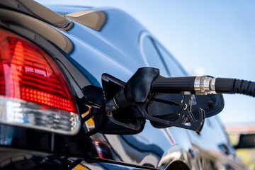 Fototapeta premium A car at gas station being filled with fuel.