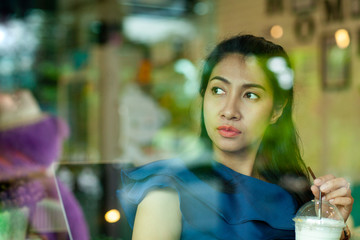 young asian woman sitting in coffee shop