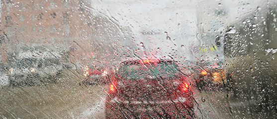 View from the car windscreen during rain and wet snow. Poor visibility while driving around the city. Snowy road. - obrazy, fototapety, plakaty