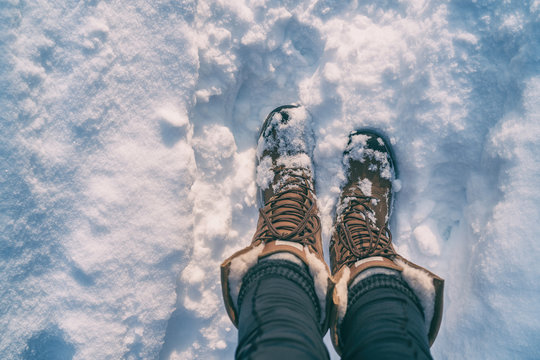 Winter hiking in Snow boots walking first person POV selfie of feet in deep cold snowfall in outdoors forest. Girl taking picture of her shoes.
