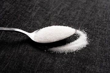 Close-up of sugar in silver spoon.