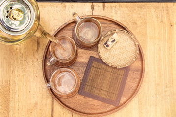 Top view Pour the tea from the kettle into a cup of tea on the table