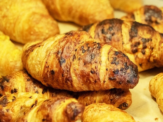 A close-up photo of freshly baked ruddy croissants with a golden crust