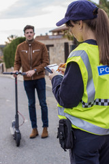 policeman stops a boy on electric scooter
