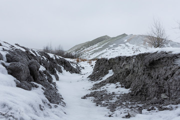 Frozen earth in abstract form. Ground is covered with snow.
