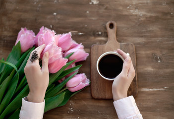 Fototapeta na wymiar beautiful pink tulips on a table near a woman