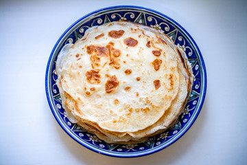 pancakes in a blue dish on a light background.