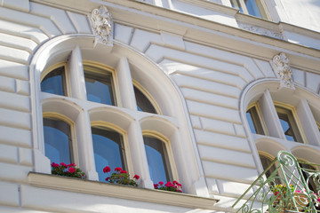 The architecture of the Old Town part of the Prague. Details and elements of architectural decorations on the facades of houses. Windows with flowers close up.