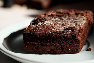 Homemade chocolate cake in white dish and sunlight and space for write wording, unhealthy sweet caused dangerous chronic illness such as diabetes, popular sweet sold in restaurant.