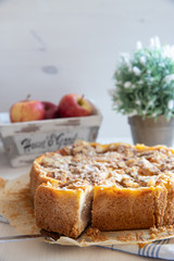Bratapfelkuchen mit Äpfeln und Mandelblättchen auf hellem weißen Holzgrund