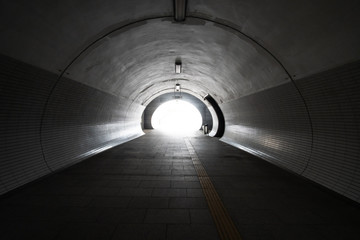 Exit from the empty round concrete tunnel outside, with light in the end. Inside empty round tunnel.