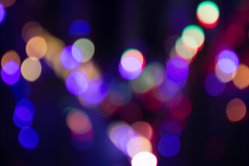 Abstract background with defocused bokeh colorful lights, glowing sparkling lights and reflections