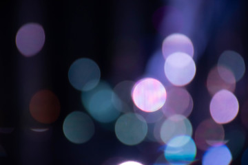 Abstract background with defocused bokeh colorful lights, glowing sparkling lights and reflections