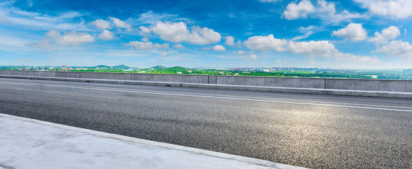 Wide asphalt highway and city suburb skyline on a sunny day in Shanghai,panoramic view.