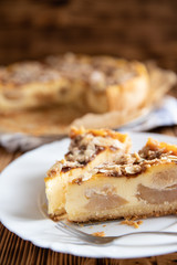 Bratapfelkuchen mit Äpfeln und Mandelblättchen auf dunklen Holzgrund