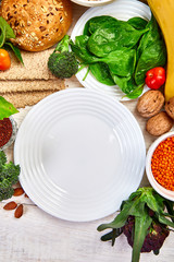 Selection food rich in fiber on white wooden background around empty plate