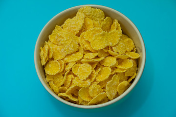 Corn flakes on a bright blue background, close-up