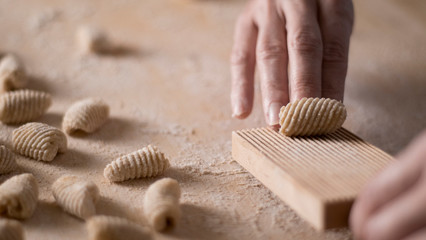 Close up process of homemade vegan gnocchi pasta with wholemeal flour making. The home cook crawls...