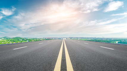 Naklejka premium Empty asphalt highway and city suburb skyline on a sunny day in Shanghai.