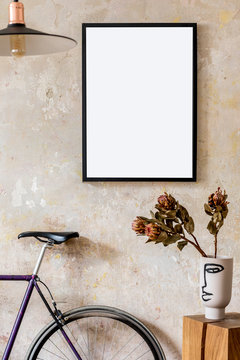 Modern composition of living room interior with black mock up poster frame,  wooden cube, flowers in vase, hipster bike and elegant personal accessories. Stylish home decor. Grunge wall. Template.