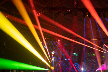 Scene, stage lights with colored spotlights and smoke, laser lights background, rainbow color, defocused