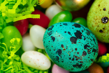 Egg shell with colorful candies inside  in a decorative Easter nest