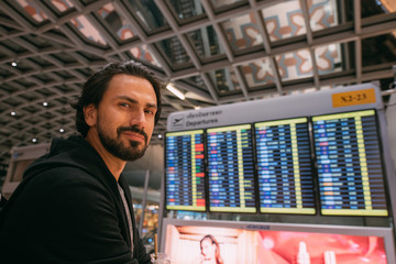 A man near the schedule board at the airport