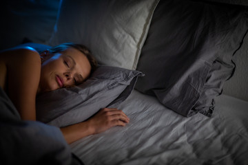 Beautiful young woman sleeping in bed (colour toned image; shallow DOF)