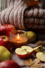 Layout of candles, apples and a knitted scarf