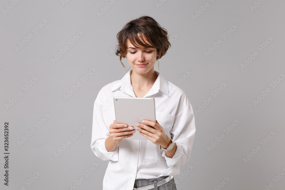 Sticker smiling young business woman in white shirt posing isolated on grey wall background studio portrait.