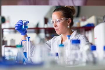 Female researcher carrying out scientific research in a lab (shallow DOF; color toned image)