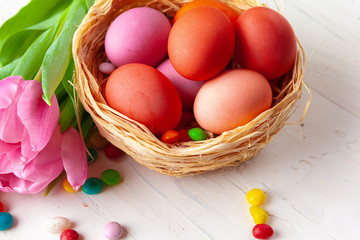 Easter composition with tulips and basket of painted eggs