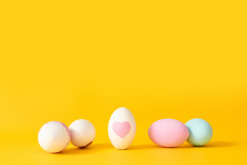 Minimal composition of decor eggs on yellow background. Happy easter card