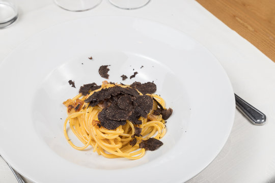 Carbonara spaghetti with black truffle served in a white plate. Gourmet Italian food.