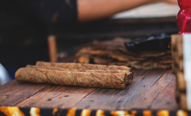 Beautiful woman making cigars. Young Mexican girl produce handmade cigar.