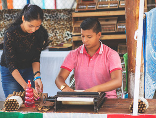 Young couple making cigars. Husband and wife produce handmade cigar. Family business. 