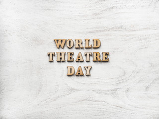 Wooden letters of the alphabet in the form of the words THEATRE DAY lying on the table. Beautiful card. Isolated background, wooden surface. Congratulations for relatives, friends and colleagues