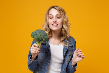 Pretty young woman in denim clothes isolated on yellow orange background. Proper nutrition...