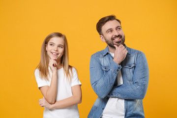 Pensive bearded man in casual clothes have fun with child baby girl. Father, little kid daughter isolated on yellow background. Love family day parenthood childhood concept. Put hand prop up on chin.